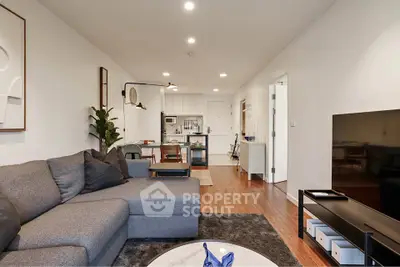 Modern living room with open kitchen layout, stylish decor, and cozy seating area in a contemporary apartment.