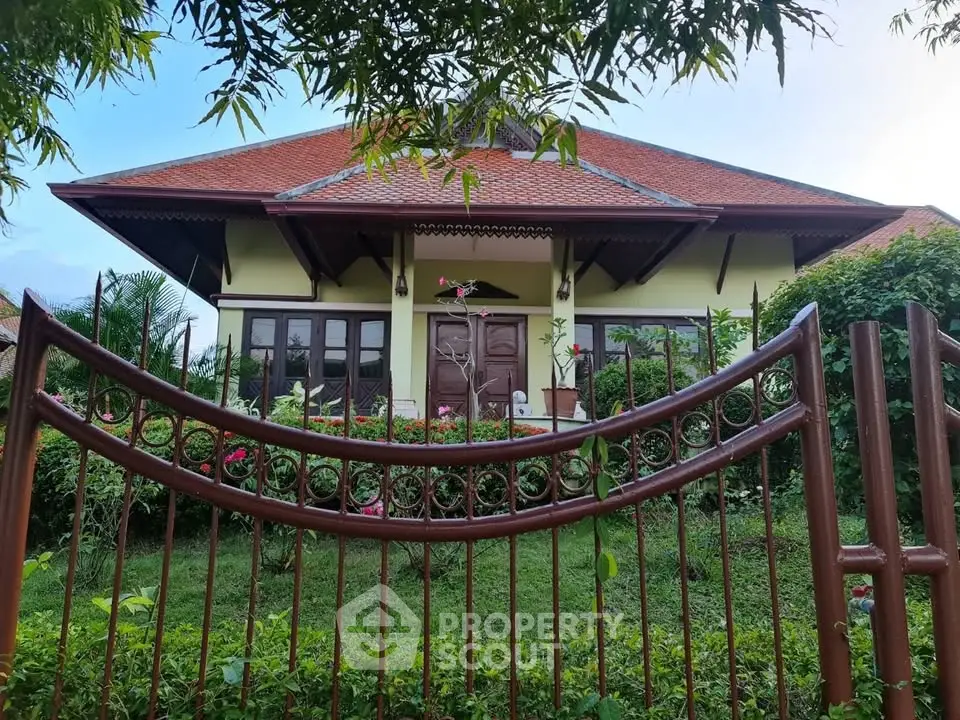 Charming single-story home with lush garden and elegant entrance gate, perfect for serene living.