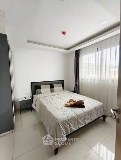 Modern bedroom with large window and stylish decor in a contemporary apartment.