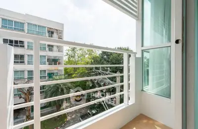 Charming balcony with modern railing and scenic view of lush greenery and urban landscape.