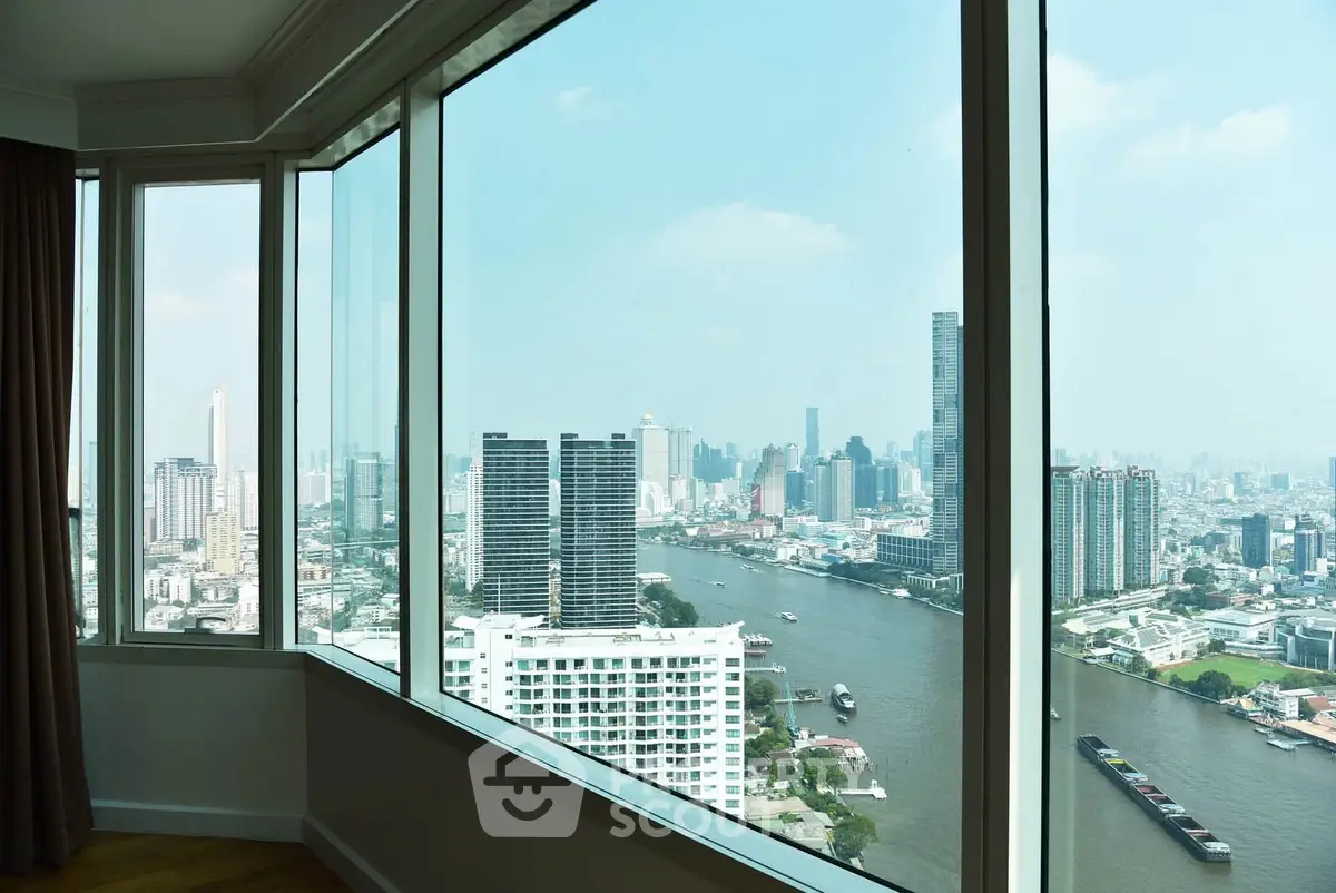 Stunning cityscape view from a high-rise apartment window overlooking a river and skyline.