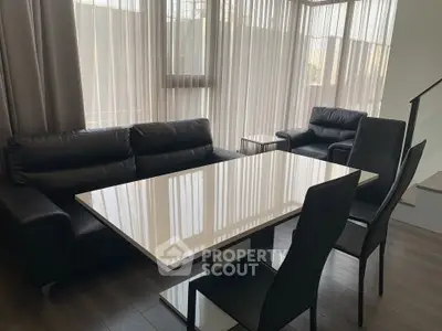 Modern living room with sleek black furniture and large windows for natural light