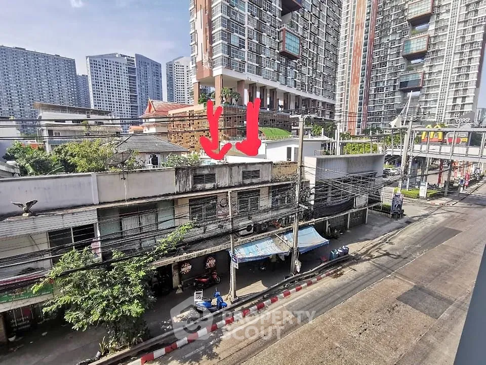 Urban street view with residential and commercial buildings, showcasing city living and real estate potential.