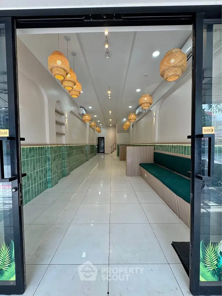 Elegant building entrance with modern lighting and green tile accents