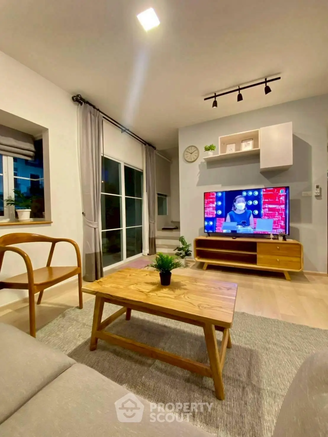 Modern living room with stylish furniture and wall-mounted TV, perfect for relaxation.