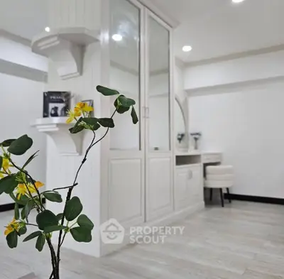 Elegant interior with white cabinetry and floral decor in a modern living space.