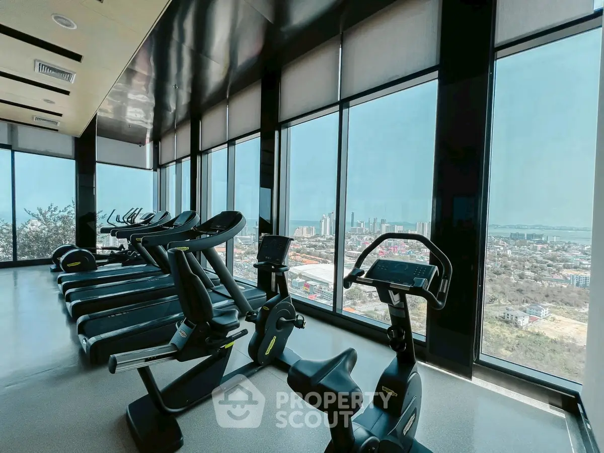 Modern gym with panoramic city view and state-of-the-art equipment.