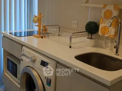 Modern kitchen with washing machine and sleek countertop