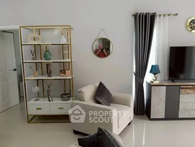 Modern living room with stylish decor, featuring a cozy armchair, elegant shelving, and a sleek TV stand.