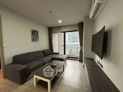 Modern living room with sleek furniture and city view balcony in high-rise apartment.