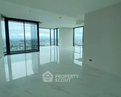 Spacious modern living room with panoramic city views and floor-to-ceiling windows.
