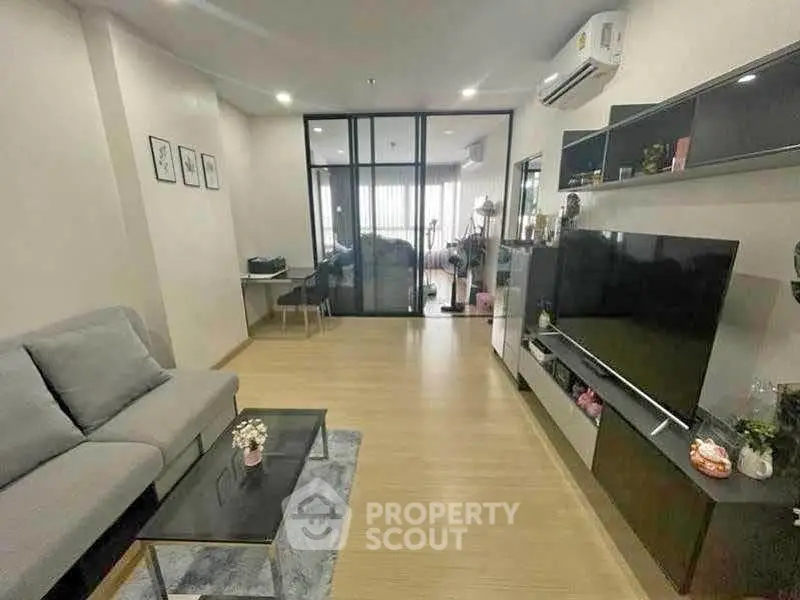 Modern living room with sleek furniture and glass partition, perfect for stylish urban living.