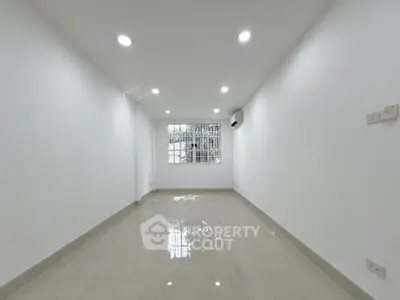 Spacious empty room with glossy tiled floor and bright lighting, ideal for customization.