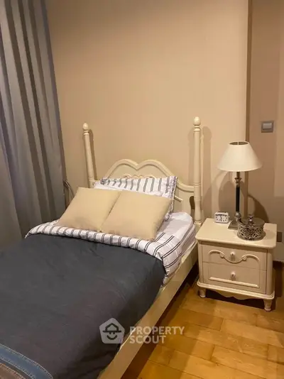 Cozy bedroom with elegant bed and stylish nightstand in a warm, inviting setting.