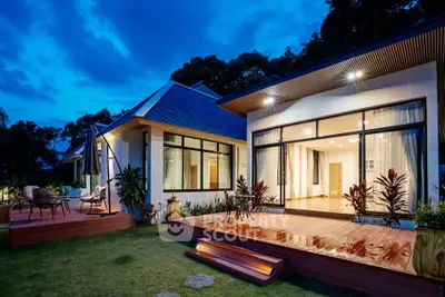 Stunning modern home with expansive deck and lush garden, perfect for evening relaxation.