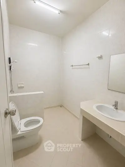 Spacious minimalist bathroom with modern fixtures and neutral tiles, perfect for a sleek and clean design.