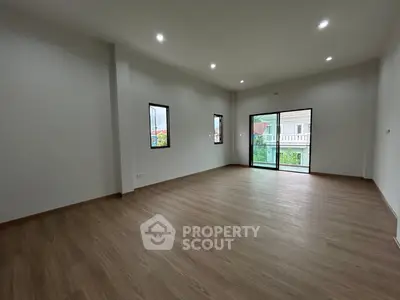 Spacious modern living room with large windows and wooden flooring