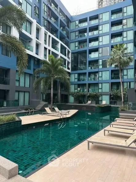 Modern apartment complex with pool and palm trees, ideal for luxury living.