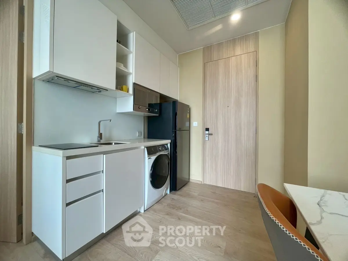 Modern compact kitchen with integrated appliances and sleek cabinetry