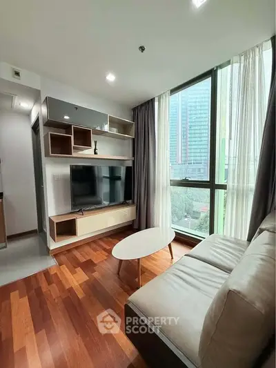 Modern living room with large window and stylish furniture in urban apartment.