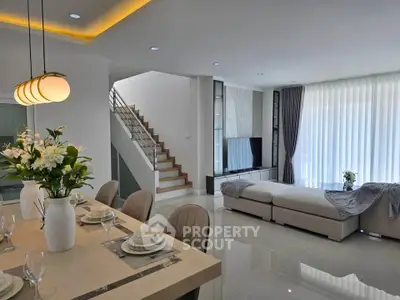 Luxurious open-plan living room with elegant dining area and modern staircase