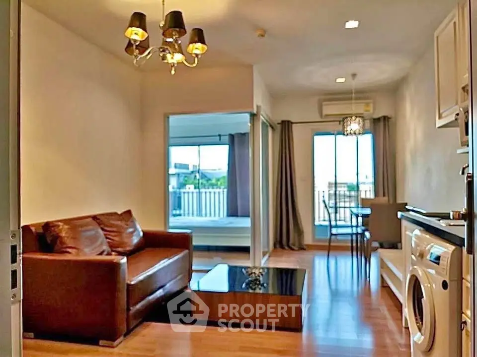Modern living room with leather sofa, open layout, and balcony view in stylish apartment.