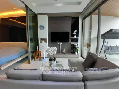 Luxurious living room with modern decor and adjacent bedroom, featuring sleek furniture and elegant design.