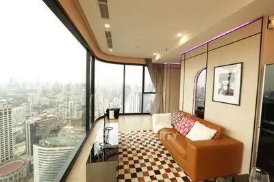 Luxurious high-rise living room with panoramic city views and modern decor.
