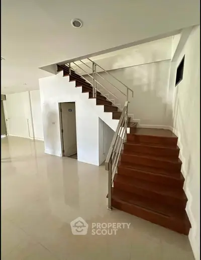 Spacious modern interior with sleek staircase and polished floors, ideal for contemporary living.