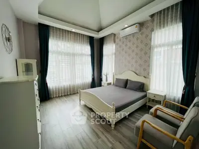 Spacious bedroom with elegant decor and large windows in a modern home.