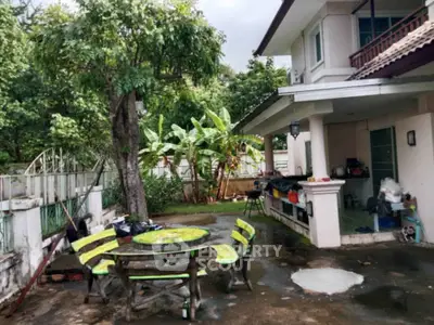 Charming suburban home with lush garden and outdoor dining area, perfect for family gatherings.