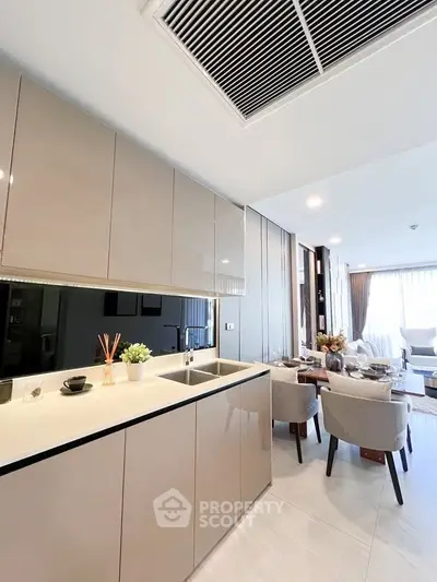 Modern open-layout kitchen and dining area with sleek cabinetry and elegant decor.