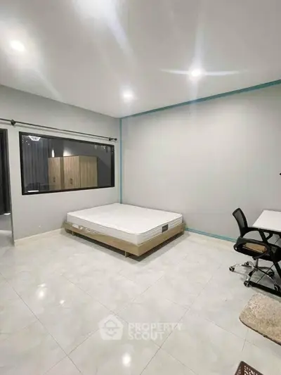 Spacious bedroom with modern minimalist design and ample natural light