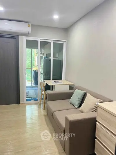 Modern living room with cozy sofa and dining area in a compact apartment.