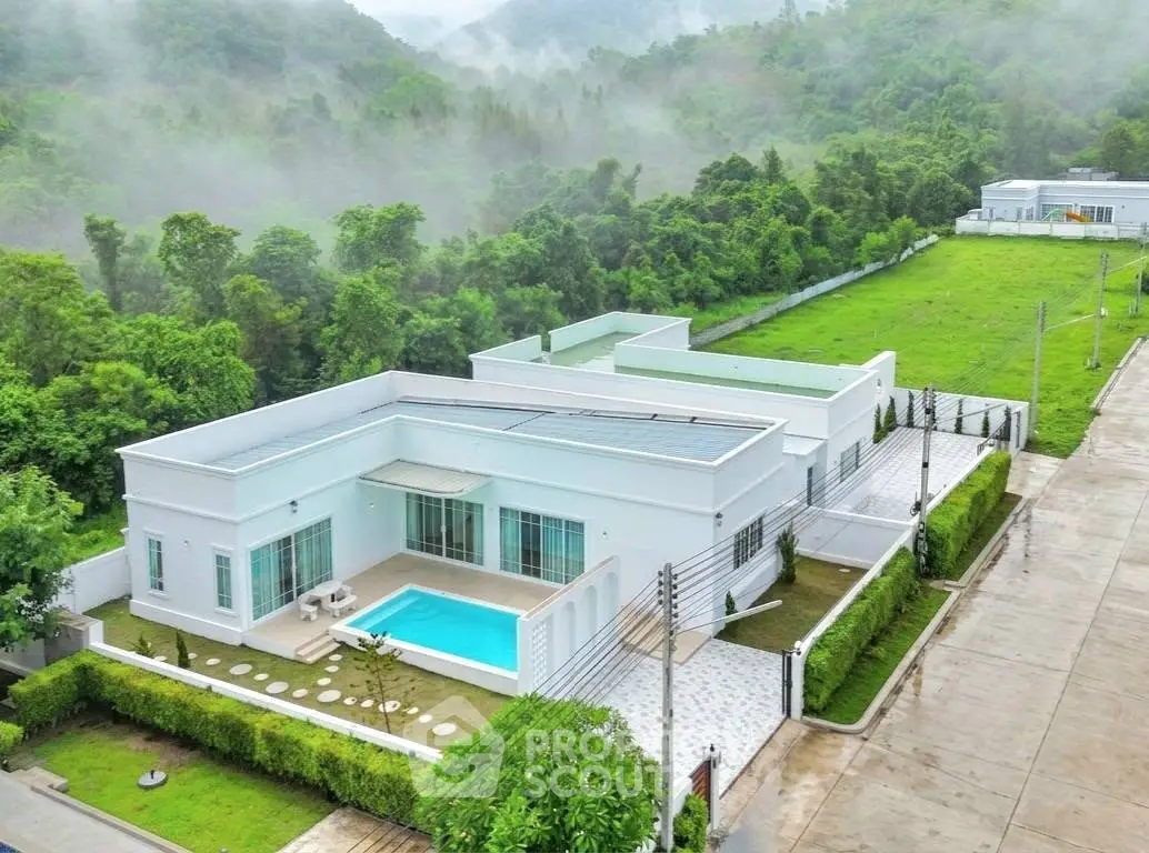 Luxurious modern villa with private pool and lush greenery in serene mountain setting.