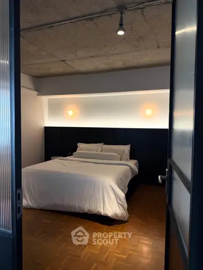 Modern bedroom with stylish lighting and parquet flooring in urban apartment