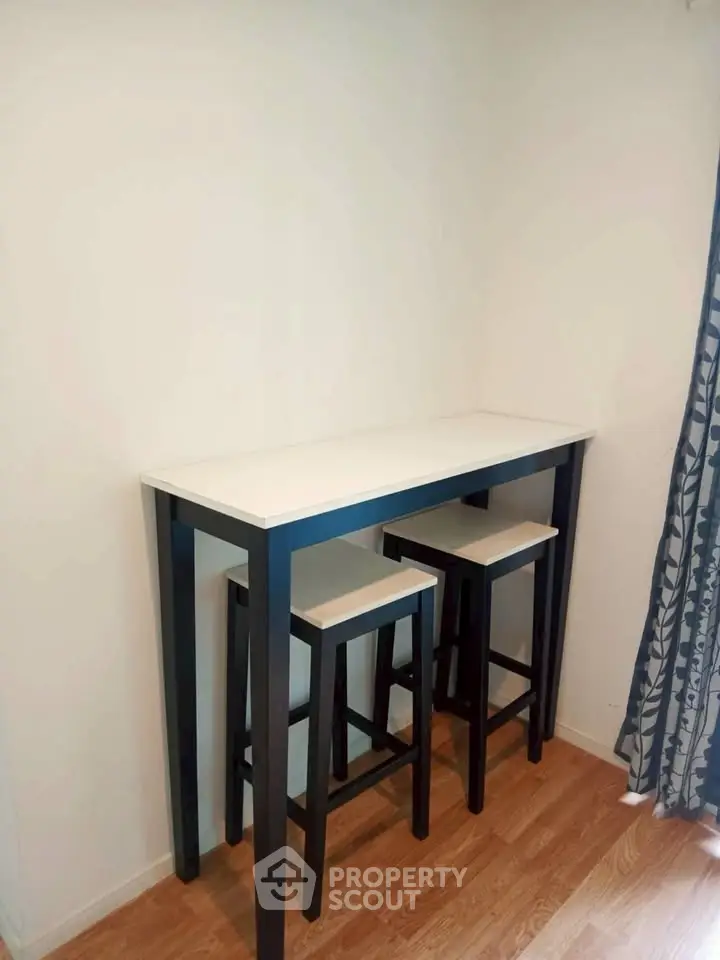 Cozy corner with high table and stools, perfect for small dining or workspace.
