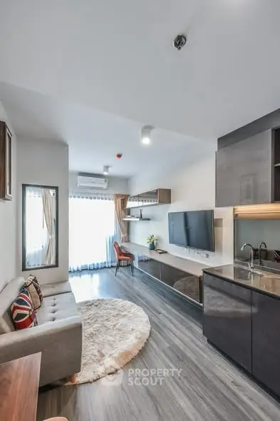 Modern living room with sleek kitchen, stylish decor, and ample natural light in a contemporary apartment.