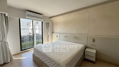 Modern bedroom with large window and air conditioning in a stylish apartment.