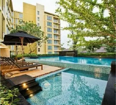 Luxurious apartment complex with stunning outdoor pool and lush greenery.
