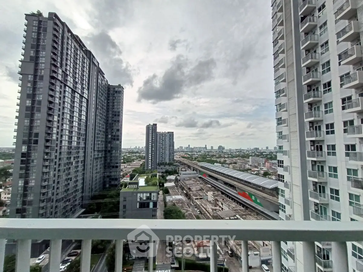 Stunning urban view from high-rise balcony overlooking cityscape and modern buildings.