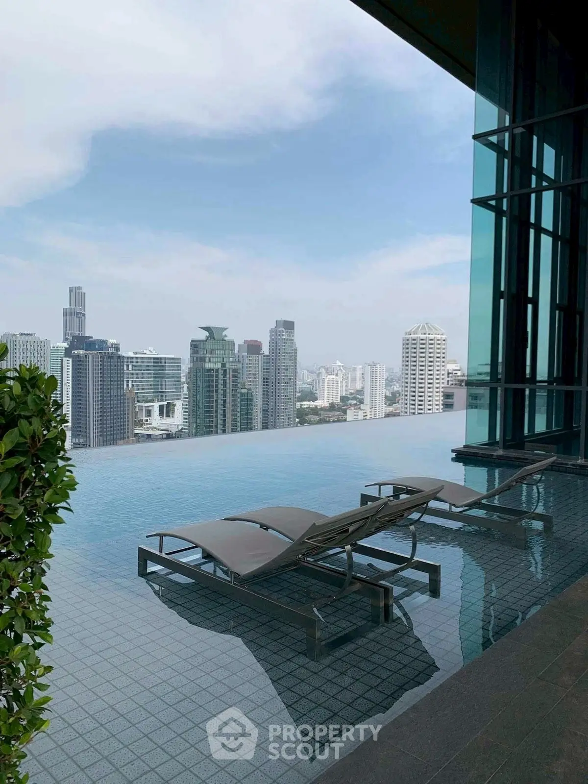 Luxurious rooftop infinity pool with stunning city skyline view, perfect for relaxation and urban living.