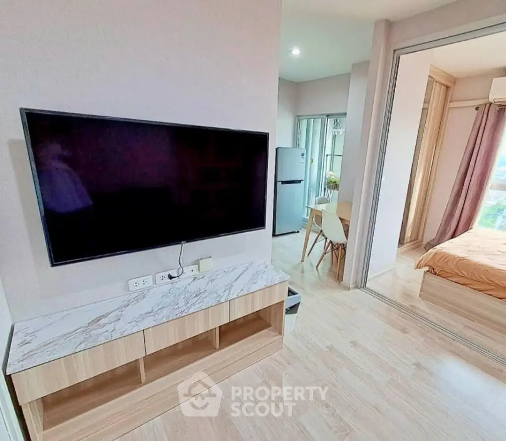 Modern apartment interior with TV, dining area, and bedroom view