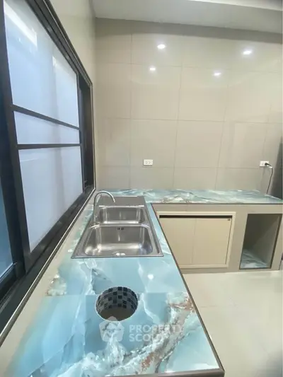 Modern kitchen with sleek countertops and stainless steel sink