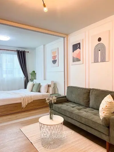 Stylish modern living room with green sofa and cozy bedroom in open layout apartment.