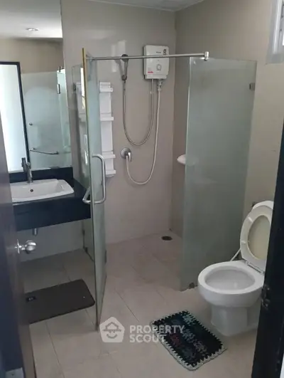 Modern bathroom with glass shower enclosure and sleek fixtures.