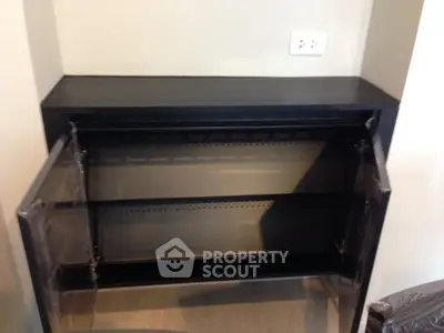 Modern black storage cabinet with open doors in a stylish interior setting.