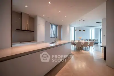 Luxurious open-plan kitchen and dining area with modern design and elegant lighting.