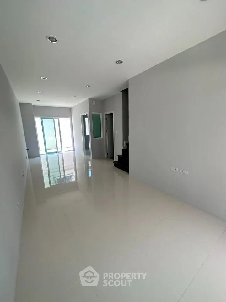 Spacious modern living room with glossy tile flooring and ample natural light.
