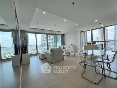 Spacious modern living room with panoramic city views and sleek furnishings.